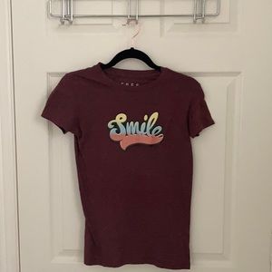 A maroon top with the word smile on the front